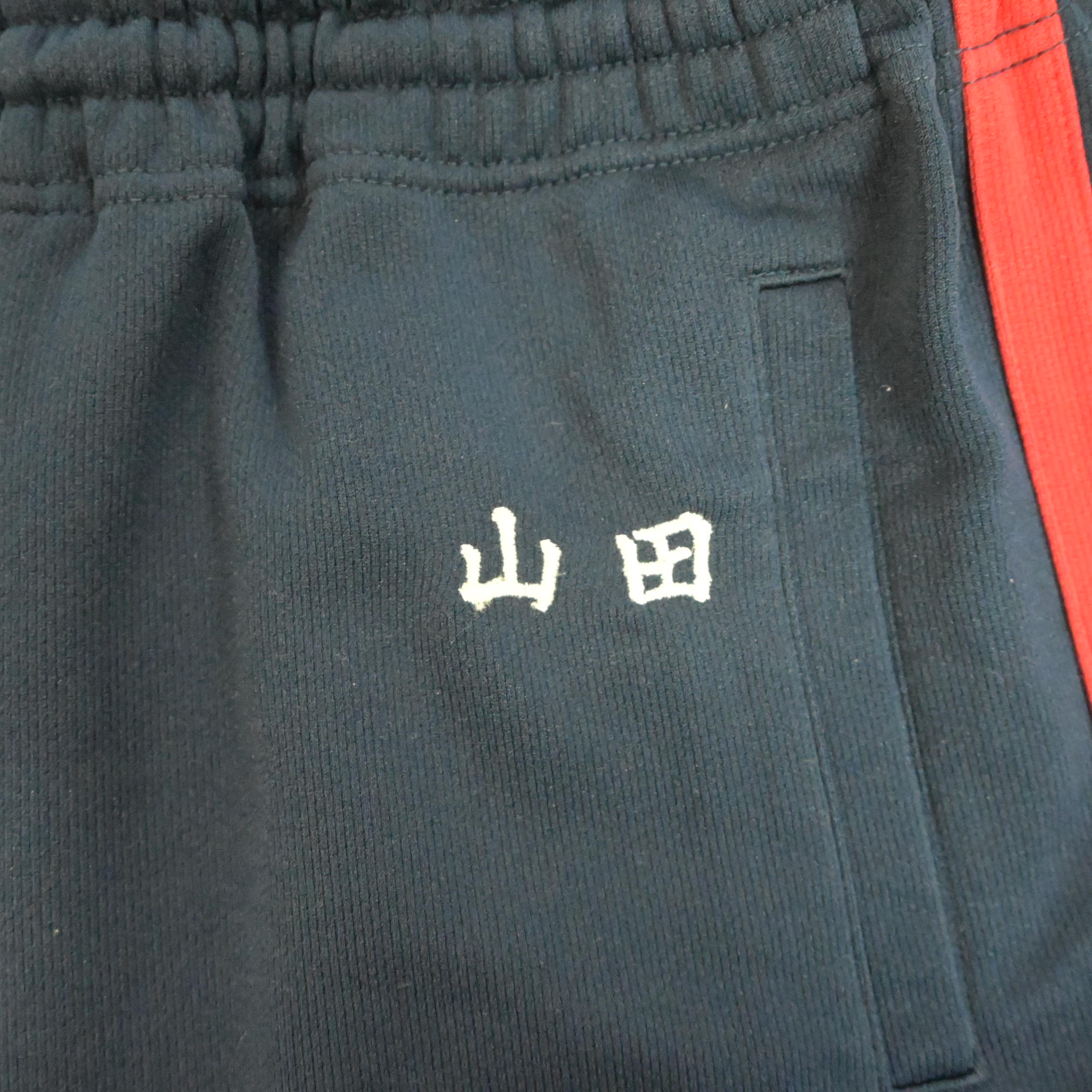 ネーム刺繍除去前の状態。ジャージに「山田」と白い刺繍がはっきり入っている