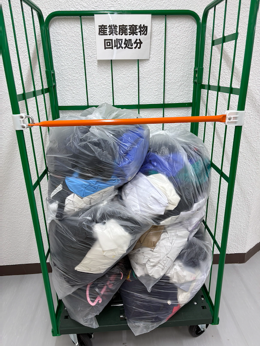 産業廃棄物として回収処分を待つ制服の山