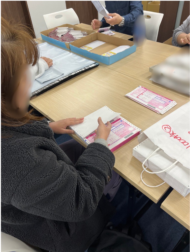 西川口カルディアのスタッフが買取キットの伝票を丁寧に封入している様子