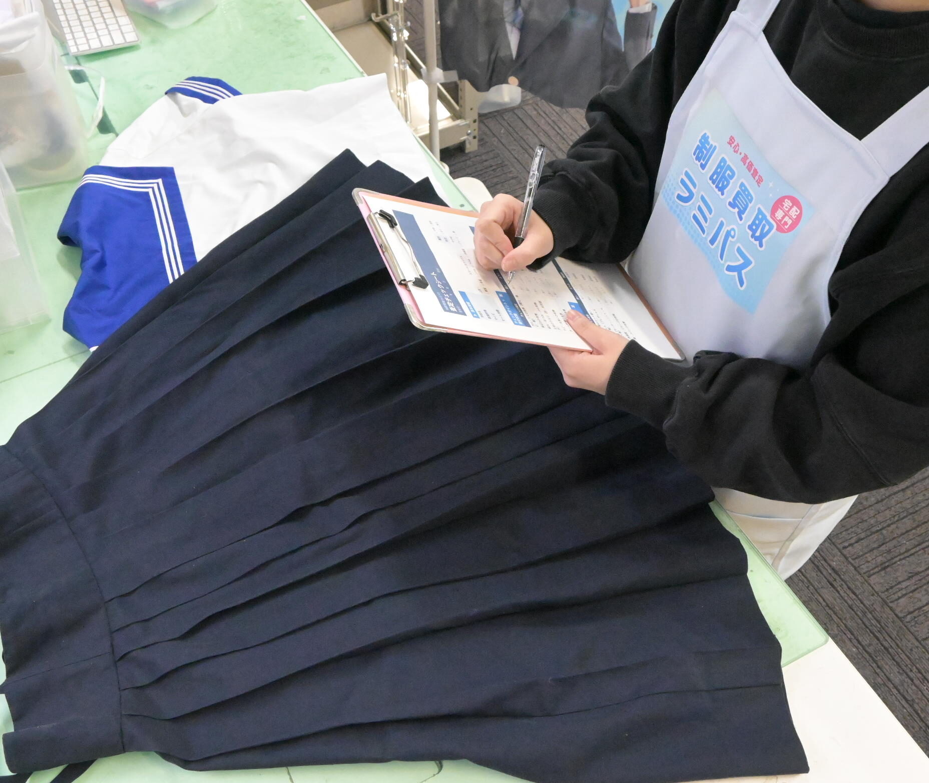 制服買取ラミパスのスタッフが制服を現物査定している様子