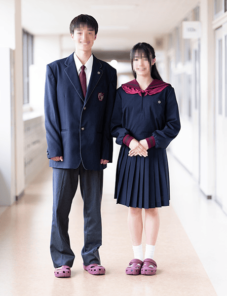 北陸学院高等学校の冬服制服 男子紺ブレザー・女子紺セーラー服(エンジリボン)