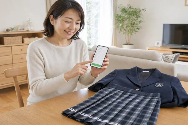 スマートフォンで買取キット不要のWEB申し込みを行い、東京女子学園高等学校の制服査定を依頼する様子