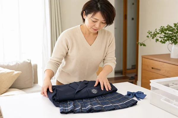 高額査定のために東京女子学園高等学校の制服を丁寧に畳んで手入れする様子