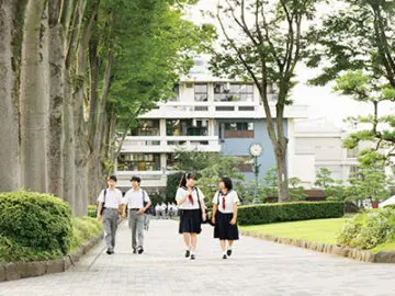 國學院大學久我山中学高等学校の生徒が夏服制服姿でキャンパスを歩く様子
