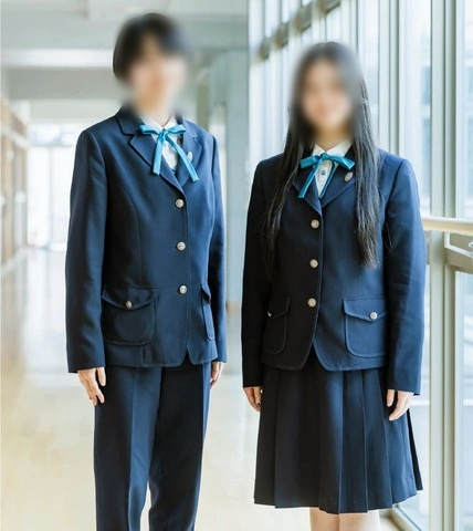 広島女学院高等学校の冬服。ボックスシルエットのブレザーにジルコニアブルーのリボンを合わせ、スラックスとスカートを着用した2人