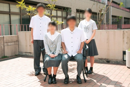 九州国際大学付属高等学校の夏服。白シャツにグレーのスラックス・スカートを合わせた男女の生徒