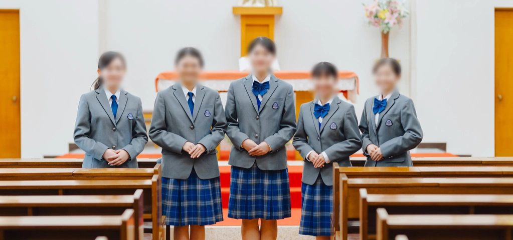 熊本信愛女学院中学高等学校の制服。グレーのブレザーとブルーのチェックスカートを着用した生徒たち