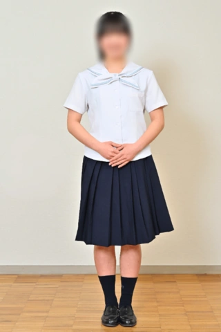京都聖母学院高等学校の夏服。水色のセーラー襟の半袖ブラウスに濃紺のプリーツスカートを合わせた女子生徒