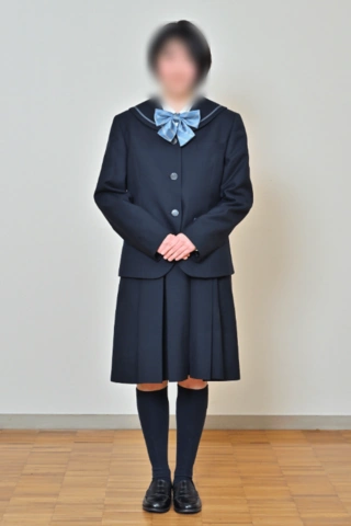 京都聖母学院中学校の冬服。濃紺のブレザーに水色のリボン、濃紺のプリーツスカートを合わせた女子生徒