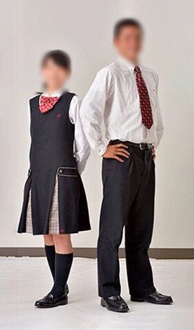 龍谷高校（佐賀）の合服。女子はジャンパースカートに赤リボン、男子は長袖シャツに赤ネクタイとスラックス