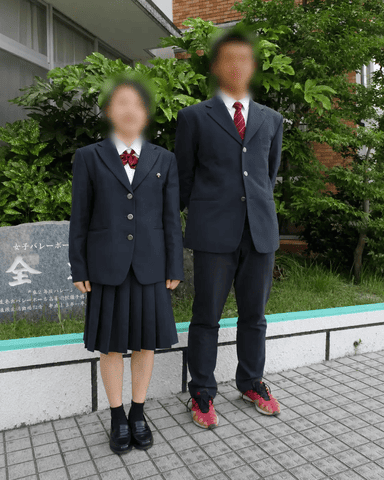 三重県立津商業高等学校の冬服(正装)。女子は紺ブレザーに赤リボンと紺プリーツスカート、男子は紺ブレザーに赤ネクタイ